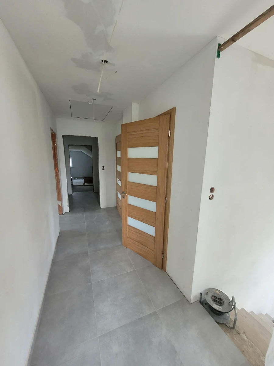 Montaż drzwi wewnętrznych w korytarzu świeżo wyremontowanego mieszkania